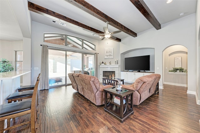 living room featuring ceiling fan, beamed ceiling, and dark wood-type flooring