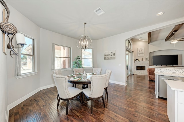 dining room featuring ceiling fan with notable chandelier, beam ceiling, and dark wood-type flooring