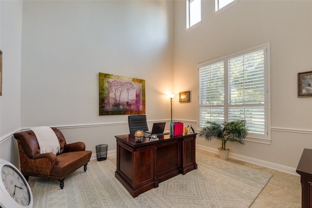 office space featuring a healthy amount of sunlight and a high ceiling