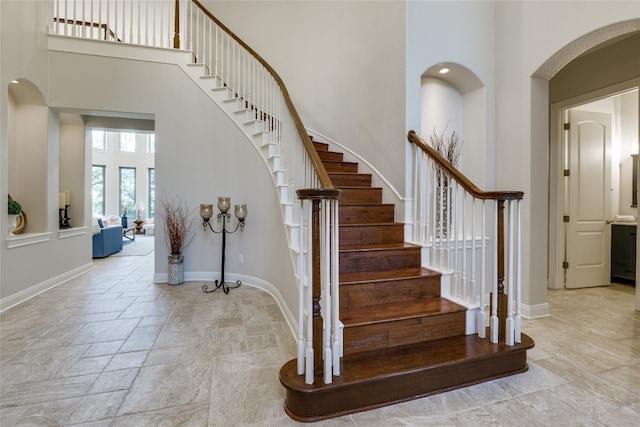 staircase featuring a towering ceiling