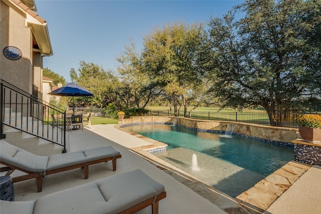 view of swimming pool with pool water feature and a patio