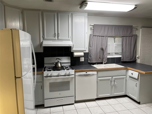 kitchen with white cabinets, light tile patterned floors, sink, white appliances, and tile countertops