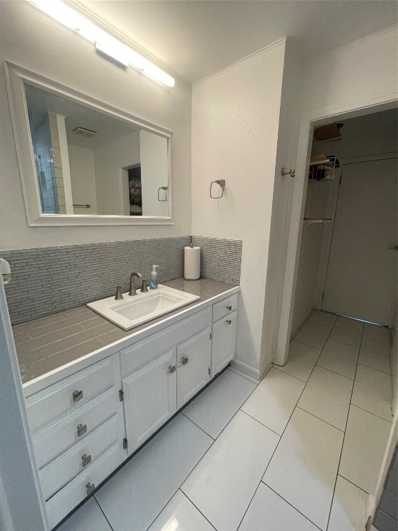 bathroom featuring vanity, tile patterned flooring, and decorative backsplash