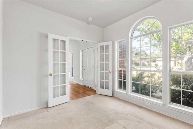 unfurnished room with light colored carpet and french doors