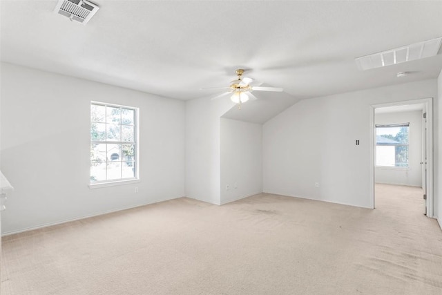 bonus room featuring ceiling fan, light colored carpet, a healthy amount of sunlight, and vaulted ceiling