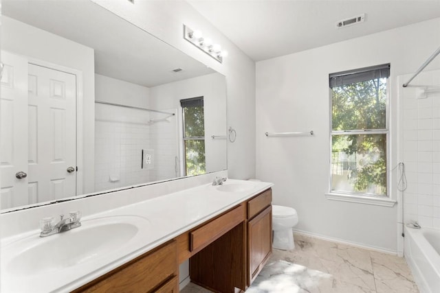 full bathroom with tiled shower / bath, plenty of natural light, vanity, and toilet