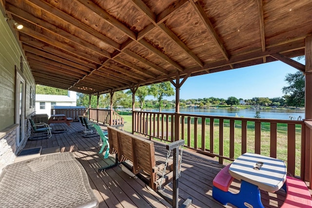 wooden deck with a yard and a water view