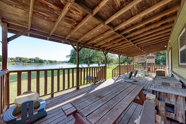 wooden deck with a water view and a yard