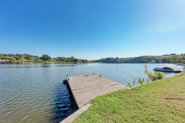 view of dock featuring a water view and a lawn