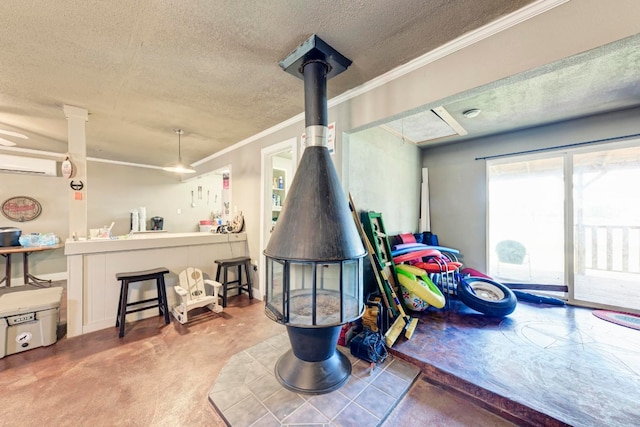 interior space featuring carpet floors, ornamental molding, a wall mounted AC, and a textured ceiling