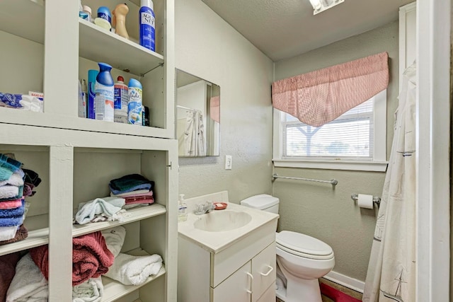 bathroom with vanity, toilet, and a textured ceiling