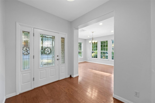 entrance foyer featuring plenty of natural light, a chandelier, and hardwood / wood-style flooring