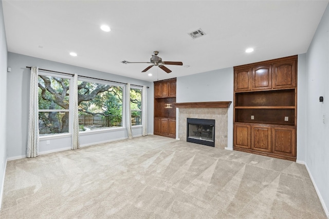 unfurnished living room with light carpet, a fireplace, and ceiling fan