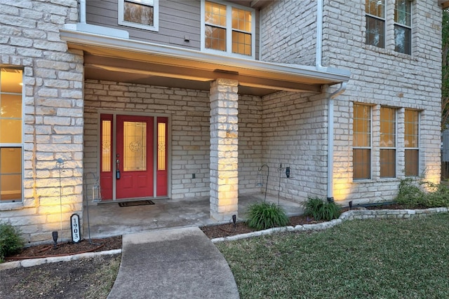 property entrance featuring a lawn