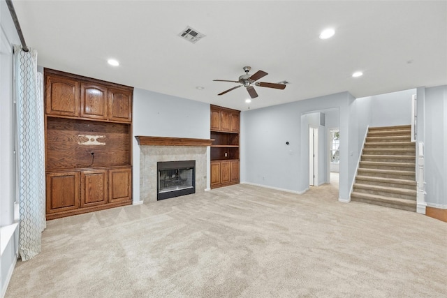 unfurnished living room with light colored carpet and ceiling fan