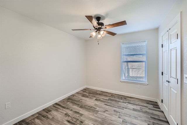 empty room with hardwood / wood-style flooring and ceiling fan