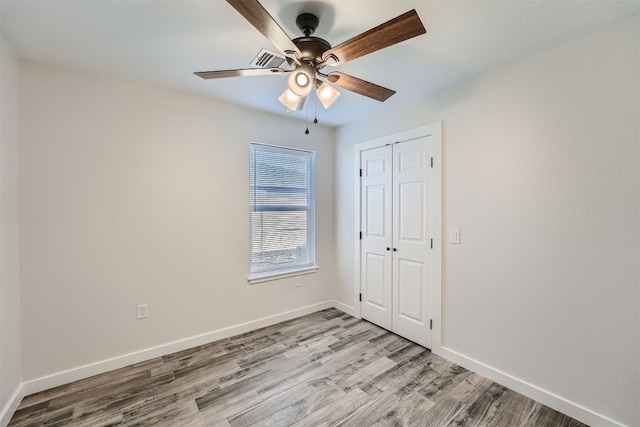 unfurnished bedroom featuring ceiling fan, a closet, and light hardwood / wood-style floors