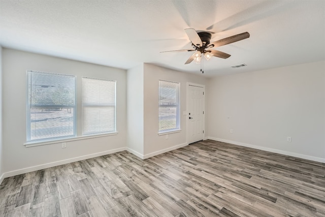 spare room with ceiling fan, a textured ceiling, and light hardwood / wood-style flooring