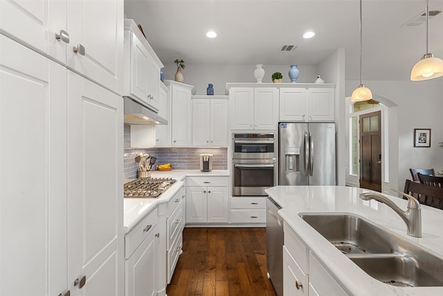 kitchen featuring dark hardwood / wood-style floors, sink, pendant lighting, white cabinetry, and appliances with stainless steel finishes