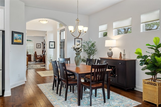 dining space with an inviting chandelier and dark hardwood / wood-style floors