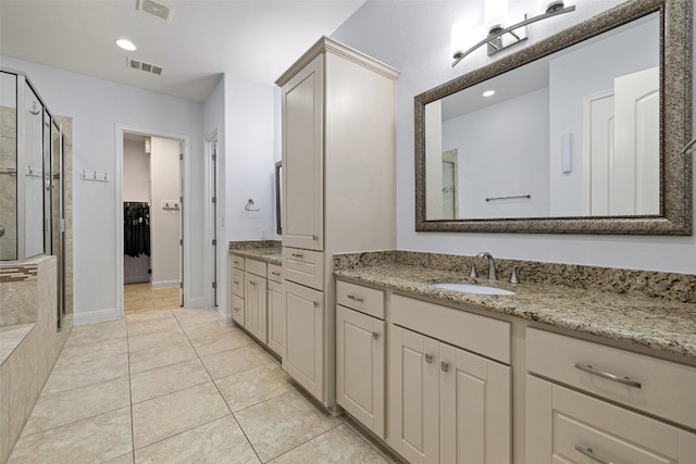 bathroom featuring vanity, a shower with door, and tile patterned floors