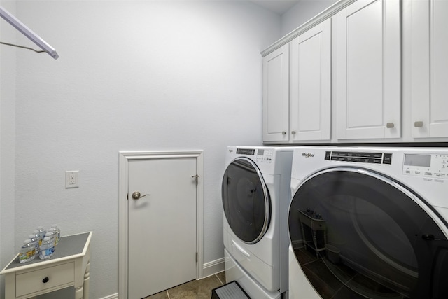 washroom featuring dark tile patterned floors, independent washer and dryer, and cabinets