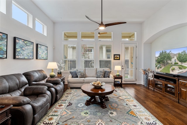 living room with ceiling fan and dark wood-type flooring