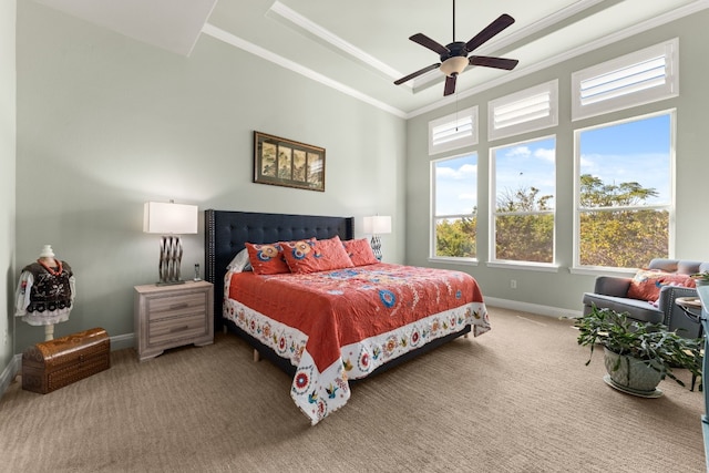 bedroom featuring a tray ceiling, ceiling fan, crown molding, and carpet floors