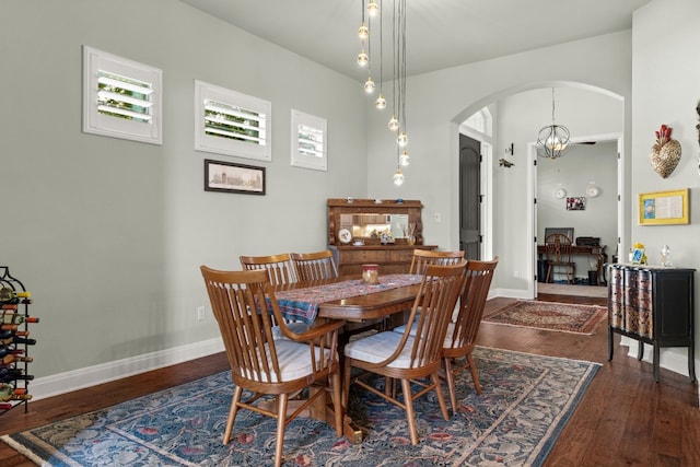 dining area featuring dark hardwood / wood-style floors and an inviting chandelier