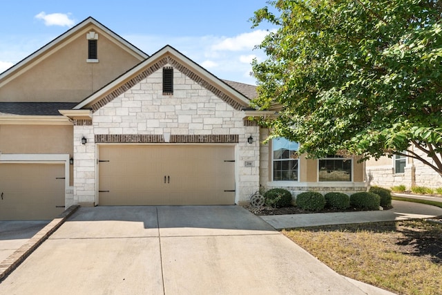 214 Darwins Way, Lakeway, TX 78734 - view of front of property with stone siding, concrete driveway, roof with shingles, and a garage