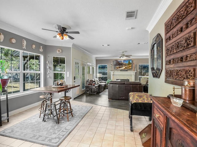 dining area featuring crown molding, a textured ceiling, and ceiling fan