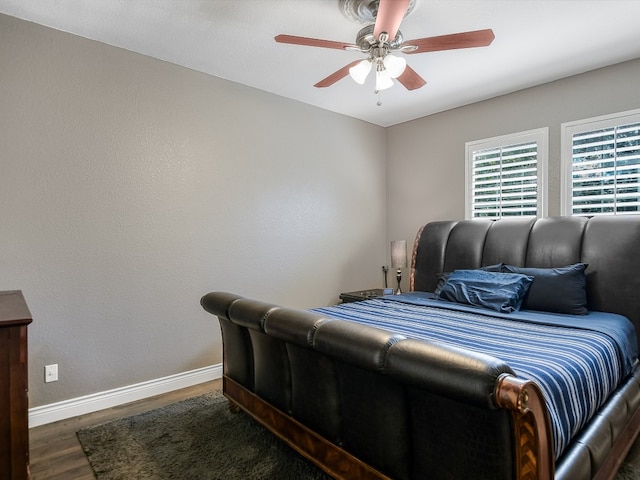 bedroom with dark hardwood / wood-style flooring and ceiling fan