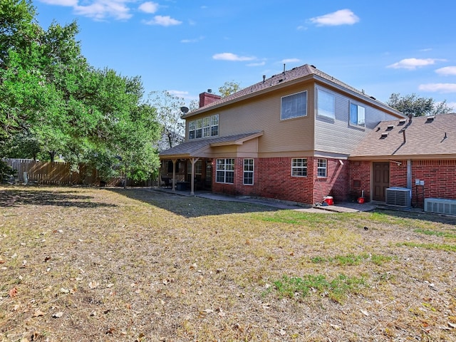 back of property with a yard, central AC, and a patio area