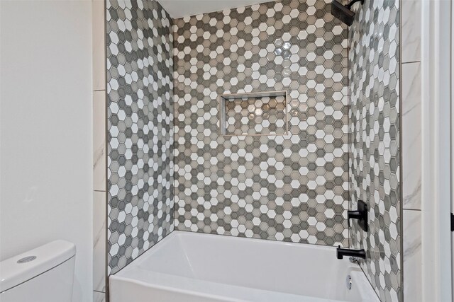 bathroom with toilet and tiled shower / bath combo