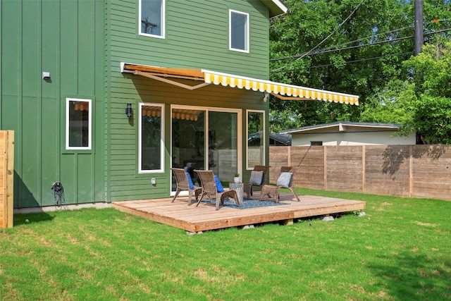 back of house featuring a deck and a yard