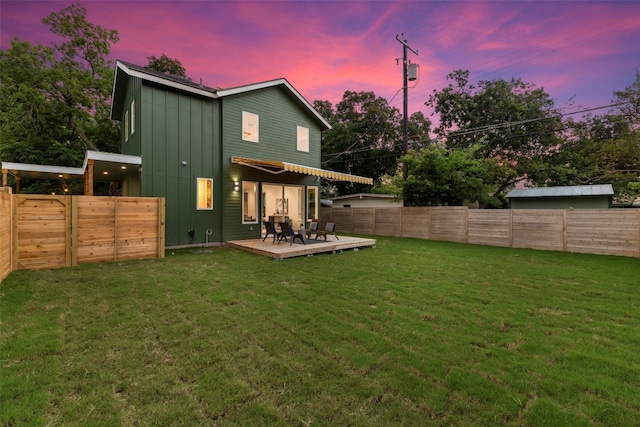 back house at dusk with a lawn