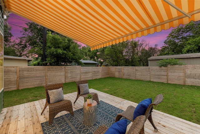 patio terrace at dusk with a wooden deck and a yard