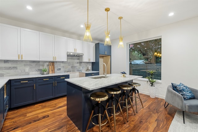 kitchen featuring a center island with sink, sink, dark hardwood / wood-style floors, and blue cabinetry