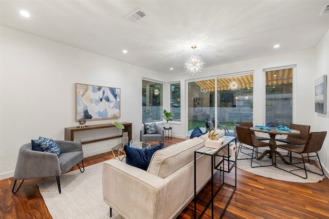 living room with hardwood / wood-style flooring and a notable chandelier