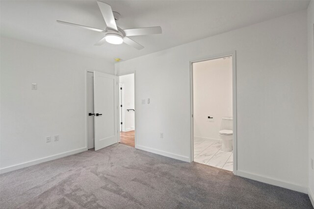 unfurnished bedroom featuring light colored carpet, ensuite bathroom, and ceiling fan