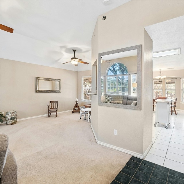 interior space with ceiling fan with notable chandelier, carpet flooring, and a wealth of natural light