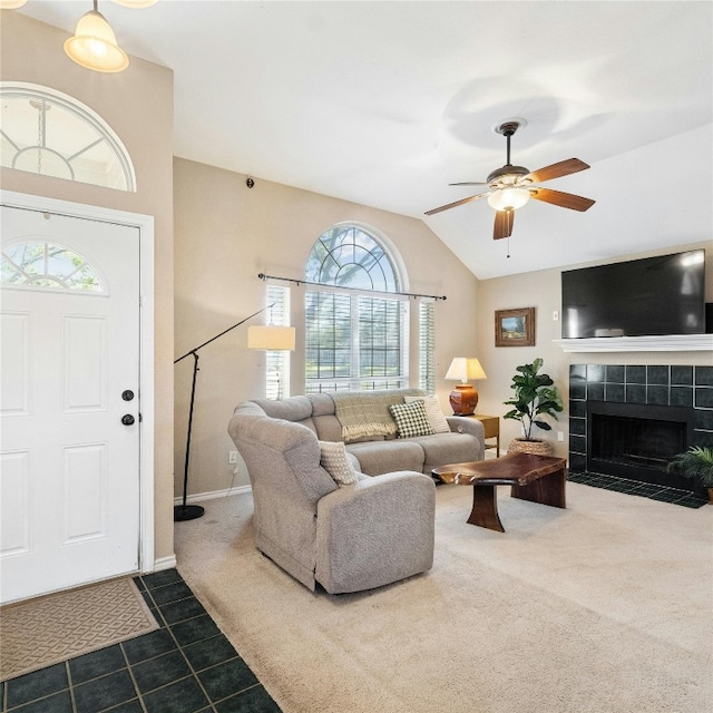 carpeted living room featuring ceiling fan, a tile fireplace, and vaulted ceiling