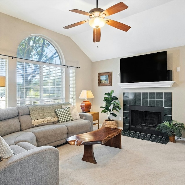 carpeted living room featuring ceiling fan, lofted ceiling, and a tile fireplace