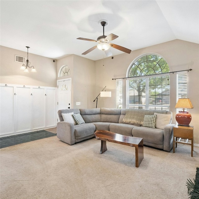 living room with light carpet, ceiling fan with notable chandelier, and vaulted ceiling