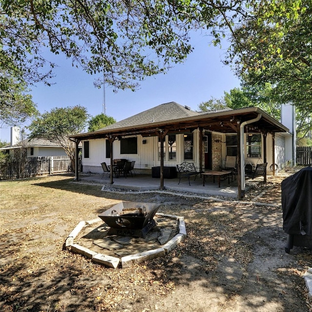 rear view of property with a fire pit and a patio area