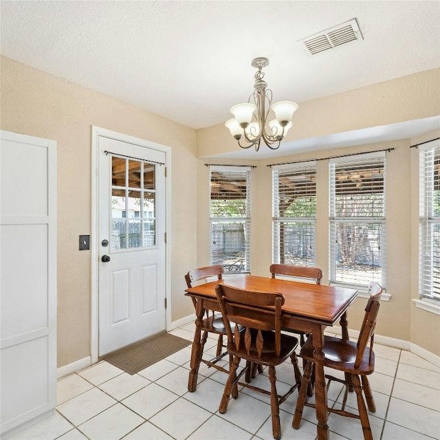 tiled dining room featuring an inviting chandelier