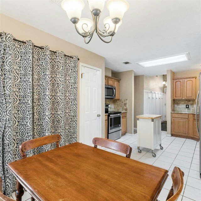 dining area featuring light tile patterned floors and a chandelier