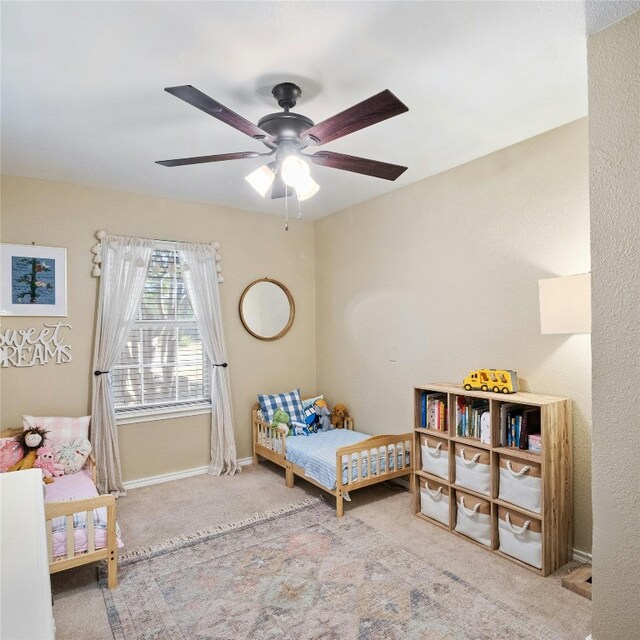 bedroom featuring ceiling fan and carpet