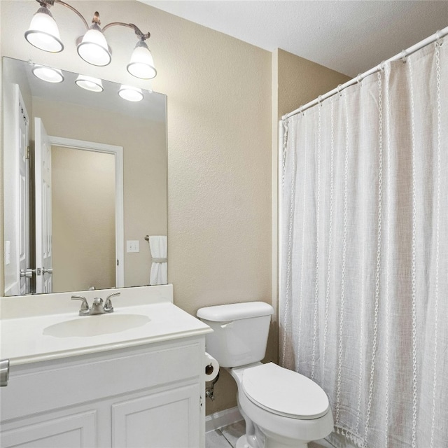 bathroom with a textured ceiling, curtained shower, vanity, and toilet