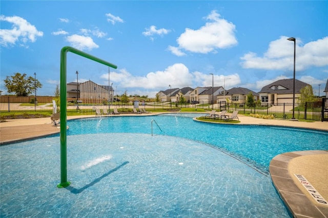 pool with a patio area, a residential view, and fence